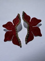Par de aros colgantes con forma de flor roja brillante y detalle de strass plateado.