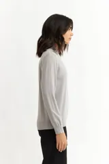 Sweater de punto color rosa pálido, con cuello alto y mangas largas.