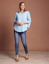 Blusa de seda fría estampada con flores en tonos celeste y rosa, marca Ruby Rd. Tiene cuello redondo con escote en V entrelazado y mangas 3/4 acampanadas.