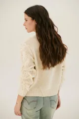 Sweater color arena de tejido de punto con cuello redondo y mangas largas con flecos.