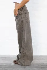 Jean de mujer color gris con efecto acid wash, de corte recto y tiro alto. Incluye bolsillos traseros y etiqueta de marca blanca en la cintura.