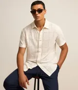 Camisa de manga corta color crema con textura cuadriculada con lesie, cuello inglés y abotonado delantero.