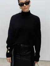Sweater negro de cuello alto, tejido de punto.