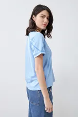 Remera celeste melange de corte clásico, con escote en V y mangas cortas con detalle de costuras en contraste.