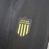 Pantalón de jogging Puma Team Goal 23 del Club Atlético Peñarol, color negro con logo de Puma en blanco y escudo del club en amarillo.