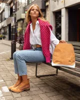 Botines de cuero marrón y blanco con diseño western, puntera redondeada y cierre lateral con cremallera. El talón tiene una tira de cuero para facilitar el calce.