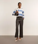Pantalón de vestir negro de corte recto, con bolsillos laterales y traseros. Se ajusta a la cintura con cinturón de cuero negro.