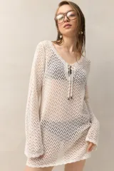 Vestido de playa tejido a crochet color blanco, con escote en V y cordones ajustables.