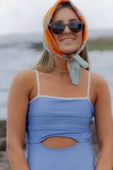 Traje de baño entero celeste metalizado con breteles finos y escote recto.