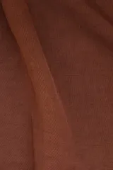 Pantalón marrón de lino y tencel, corte holgado, con cintura elástica ajustable con cordón, bolsillos laterales y detalle regulable con botón en los tobillos.