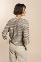 Cardigan tejido con efecto fantasia color crema. Una prenda de silueta amplia y cómoda. Tejido en 100% lana fina sin teñir.