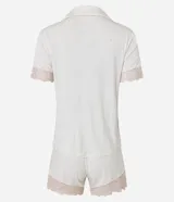 Conjunto de pijama femenino confeccionado en malla de viscosa y elastano, modelo short doll americano, compuesto por una camisa abotonada con solapa y un short con cintura elástica. Presenta un estampado de lunares y detalles de encaje en las mangas y el ruedo del short.