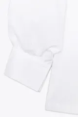 Camisa rosada de popelina de algodón, con cuello clásico, manga corta abullonada y cierre frontal con botones.