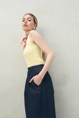 Pantalón color crema de corte ancho, con cintura alta y pinzas delanteras.