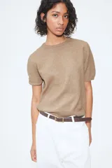 Buzo color beige de punto fino suave con cuello redondo y mangas cortas.