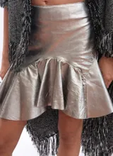 Minifalda plateada de efecto metalizado con cintura ancha y volados en el ruedo.