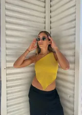 Top tejido con hilo de lurex plateado, corte asimétrico y espalda descubierta.