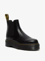 Botas Chelsea Dr. Martens modelo 2976 Quad, de cuero negro pulido, con elásticos laterales, plataforma de 4 cm y costuras amarillas.