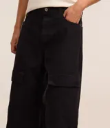 Pantalón de hombre de corte super baggy confeccionado en sarga de poliéster y algodón color negro, con bolsillos cargo laterales, cintura con trabillas y cierre de cremallera.