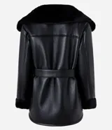 Blazer negro confeccionado en material sintético PU, con cuello y puños de piel sintética, cierre por cremallera y cinturón con hebilla en la cintura.
