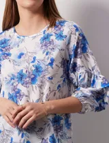 Blusa de gasa blanca, marca Sioni, con mangas 3/4 y aplique de volados.