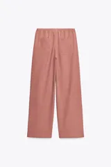 Pantalón de tiro alto color ladrillo, con cintura elástica ajustable, bolsillos delanteros y traseros. Corte ancho.