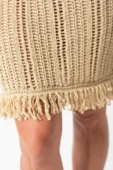Vestido corto dorado tejido al crochet con breteles finos y flecos en el ruedo.