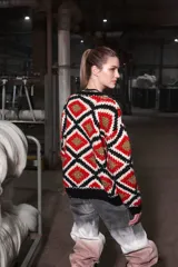 Sweater tejido de lana con diseño geométrico de rombos en colores rojo, blanco, negro y dorado.