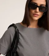 Blusa de crepé con estampado geométrico en blanco y negro, escote redondo y mangas cortas con detalle de doblez.