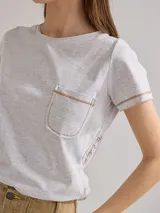 Remera gris jaspeado de algodón, corte relajado, con bolsillo en el pecho y bordado en el lateral.