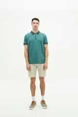 Polo blanca de manga corta con cuello gris con diseño geométrico, cierre de cremallera y logo de la marca bordado en el pecho.