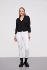 Pantalón en color negro, de corte skinny y ajuste ceñido al cuerpo.