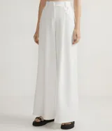 Pantalón largo de vestir color blanco, de corte palazzo, con pliegues frontales, bolsillos laterales y detalle de anilla metálica en la cintura.