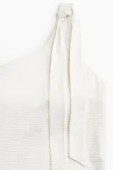 Traje de baño entero blanco con textura, de un solo hombro y bretel con moña.