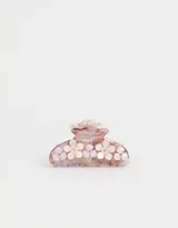 Broche para el pelo color lila con diseño de flores blancas.