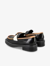 Mocasin negro con detalles en blanco, de diseño elegante y suela baja.