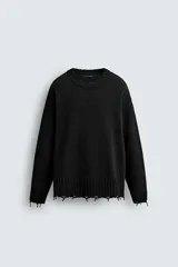 Sweater negro de punto con cuello redondo y mangas largas. Tiene un corte holgado y terminaciones irregulares con efecto desgastado en cuello, puños y ruedo.