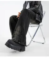 Pantalón de jean unisex modelo Oxford, color verde oscuro con efecto desgastado en tonos marrones/tostados. Presenta un corte recto o ligeramente acampanado, pinzas en los tobillos y elástico en la parte trasera de la cintura.