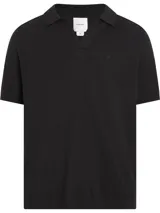 Chomba de punto negra con textura slub, cuello polo abierto y mangas cortas.