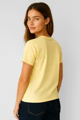 Remera amarilla de algodón con estampado abstracto marrón con efecto foil, corte al cuerpo y cuello redondo.
