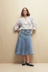 Camisa blanca bordada de algodón con diseño floral y calados, escote en V con cuello mao y mangas largas.