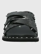 Sandalias negras de cuero con tiras cruzadas y tachas plateadas.