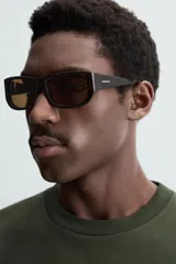 Camiseta verde oscuro de corte holgado, confeccionada en tejido de algodón grueso. Tiene cuello redondo y mangas cortas sin costura en la sisa.
