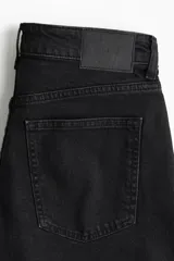 Short de denim negro con cinco bolsillos, cintura estándar con cierre y botón.