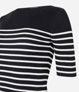 Blusa de punto con textura acanalada, escote barco y mangas 3/4. Diseño a rayas horizontales blancas y negras.