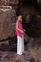 Poncho tejido de lino color fucsia, con diseño oversize y textura de punto abierto.