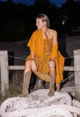 Ruana color maíz confeccionada en lana merino, de tejido suave y ligero con flecos en el borde inferior.