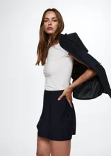 Minifalda azul marino con estampado de raya diplomática, corte ajustado, cierre lateral invisible y forro interior.