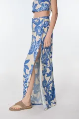 Pantalón palazzo de tiro alto con estampado floral en tonos beige y azul.