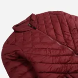 Campera color bordó con diseño matelaseado, cuello media polera, cierre frontal y puños elastizados.
